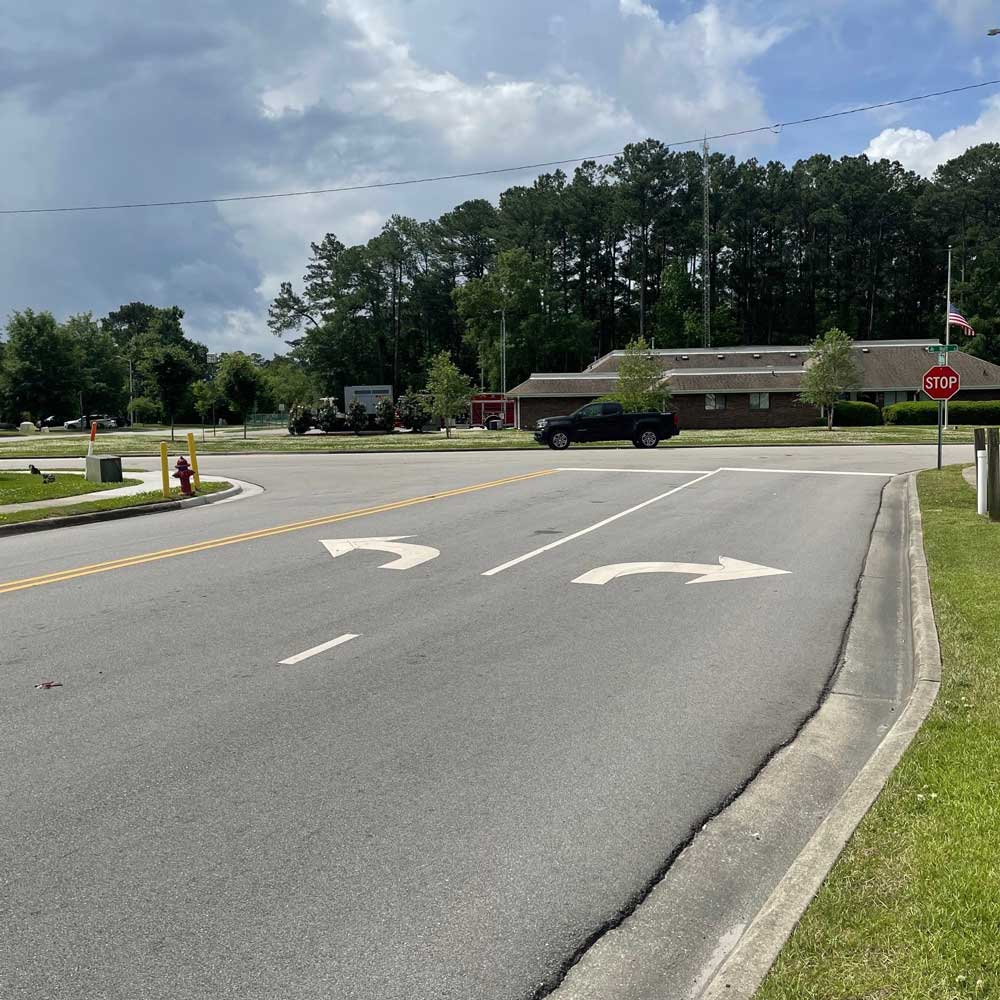 A view of the intersection at Huff Drive and Office Park Drive/Valencia Drive in Jacksonville, NC, showing road markings and traffic signage.